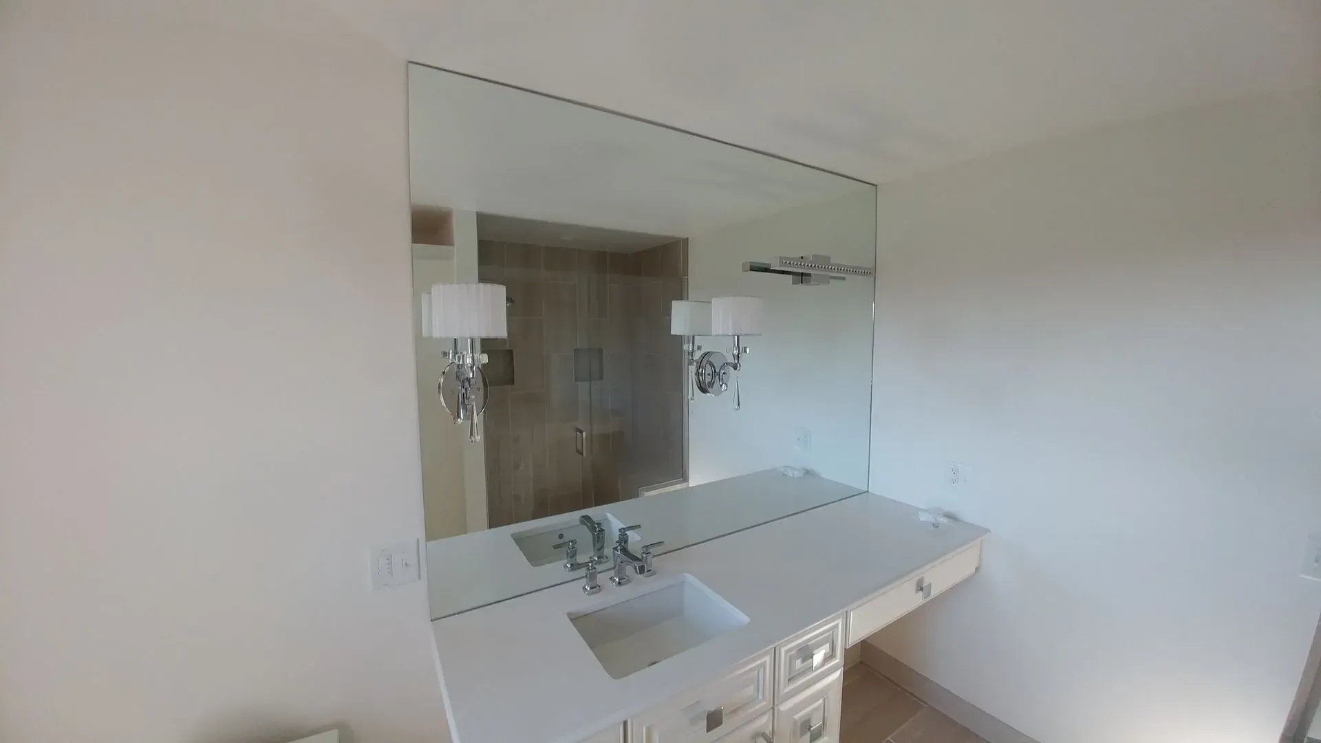 A bathroom with a large mirror and a sink.