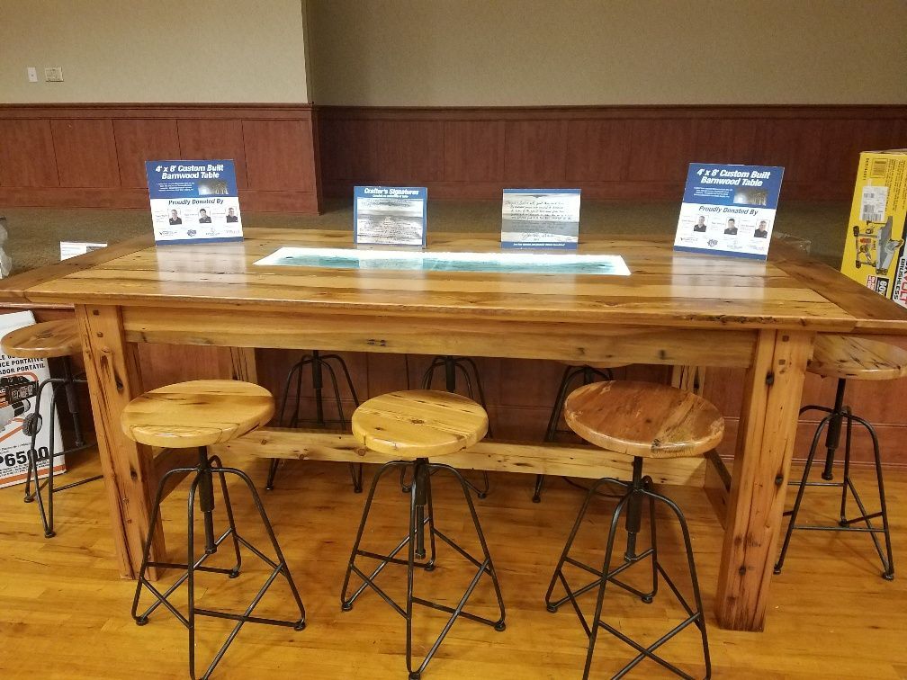 A wooden table with stools and signs on it in a room.