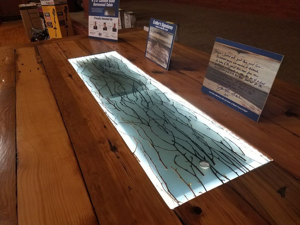 A wooden table with a glass tray underneath it