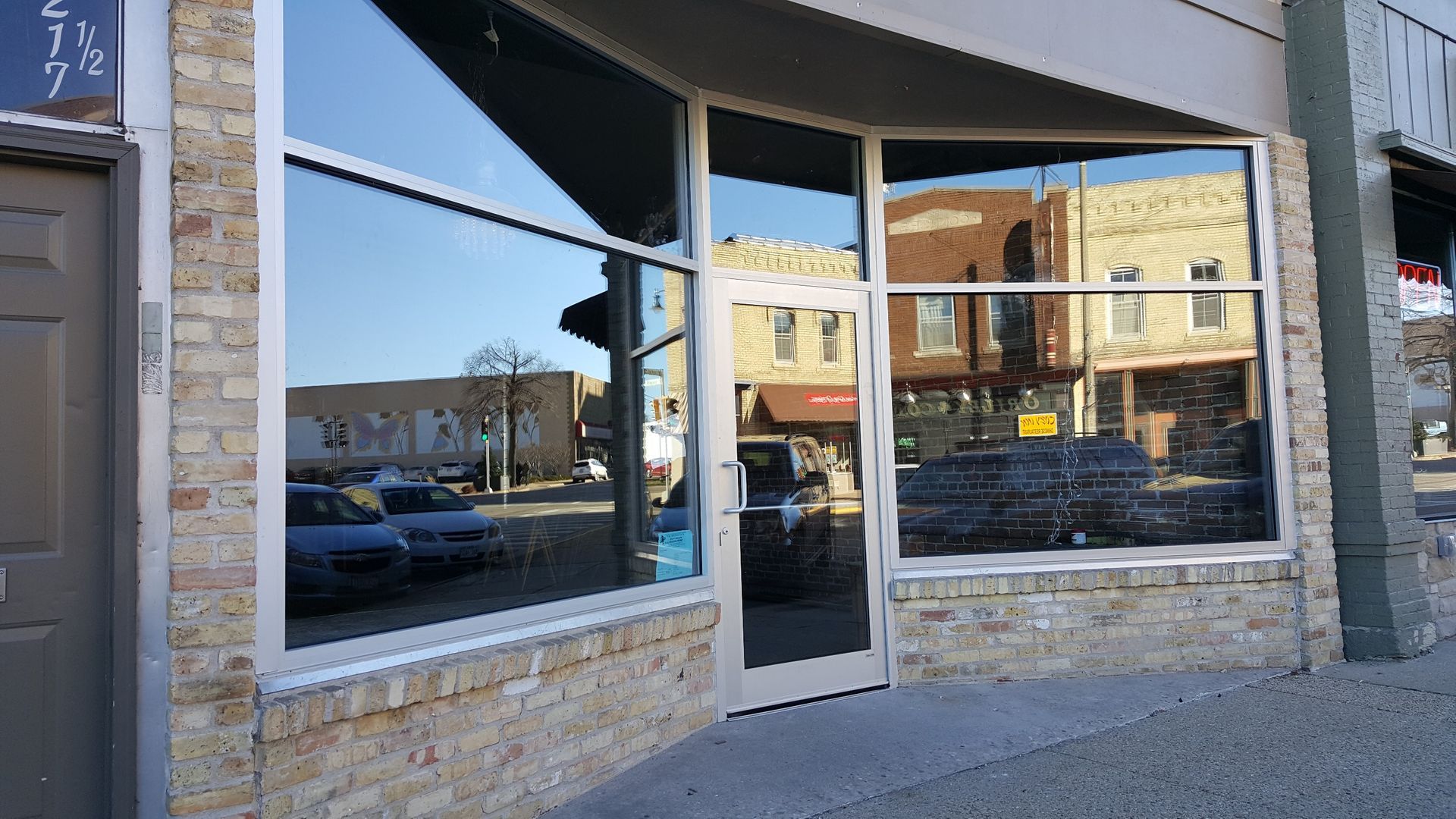 A store front with a lot of windows and a door.