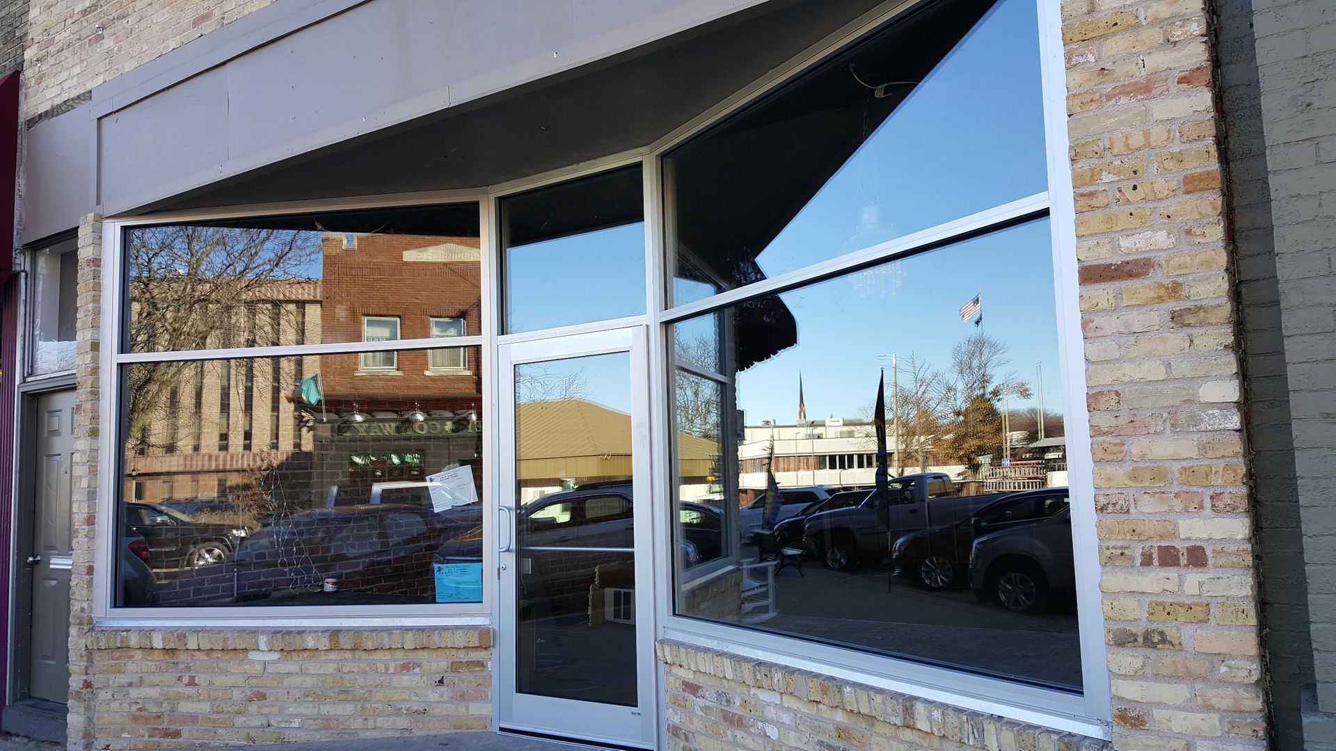 A brick building with a large window and a door.