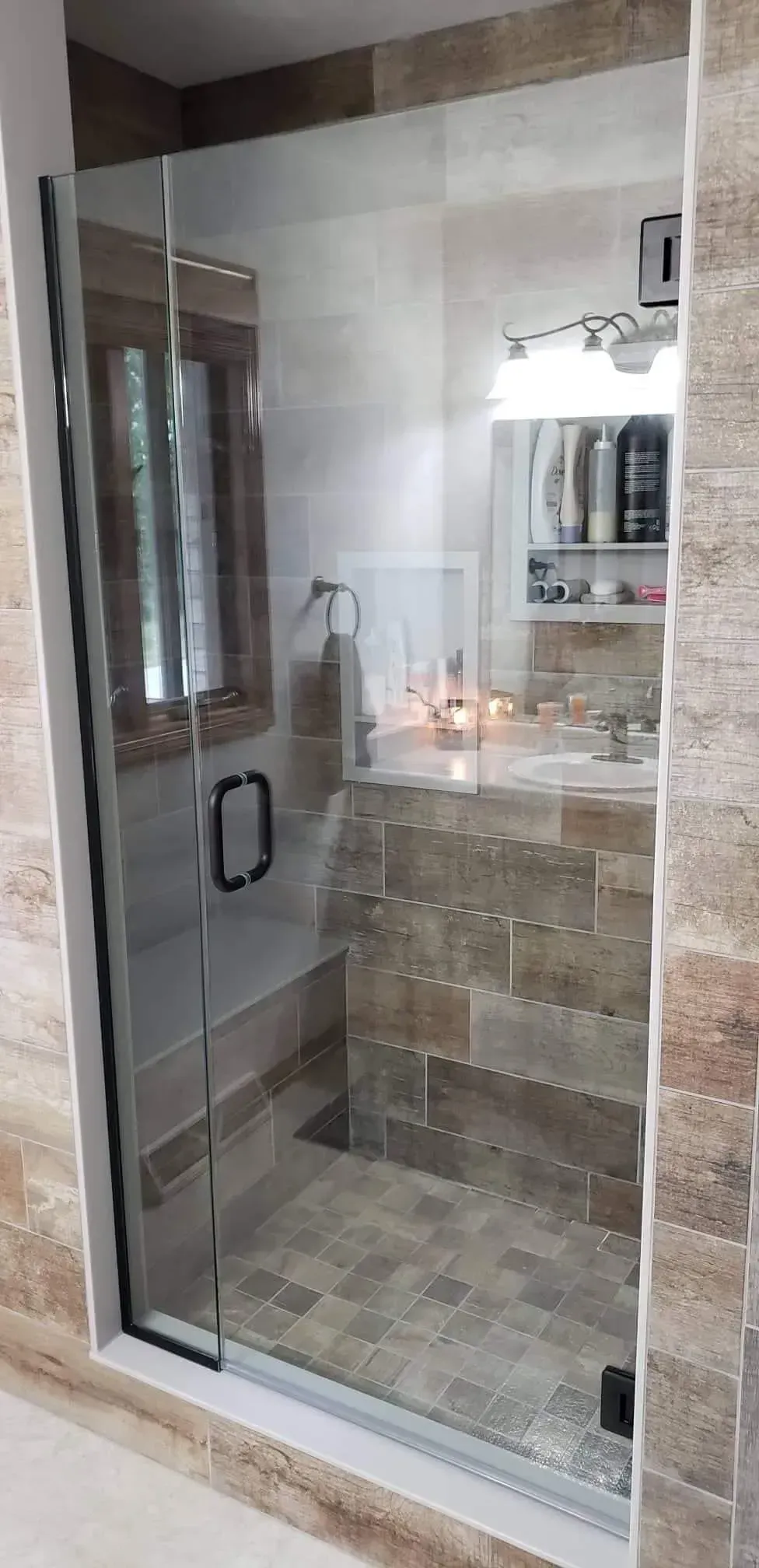 A bathroom with a walk in shower and a sink.