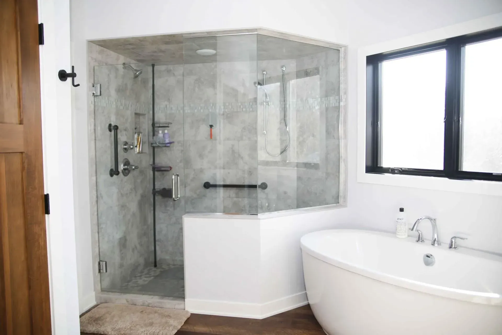 A bathroom with a tub , shower , and window.