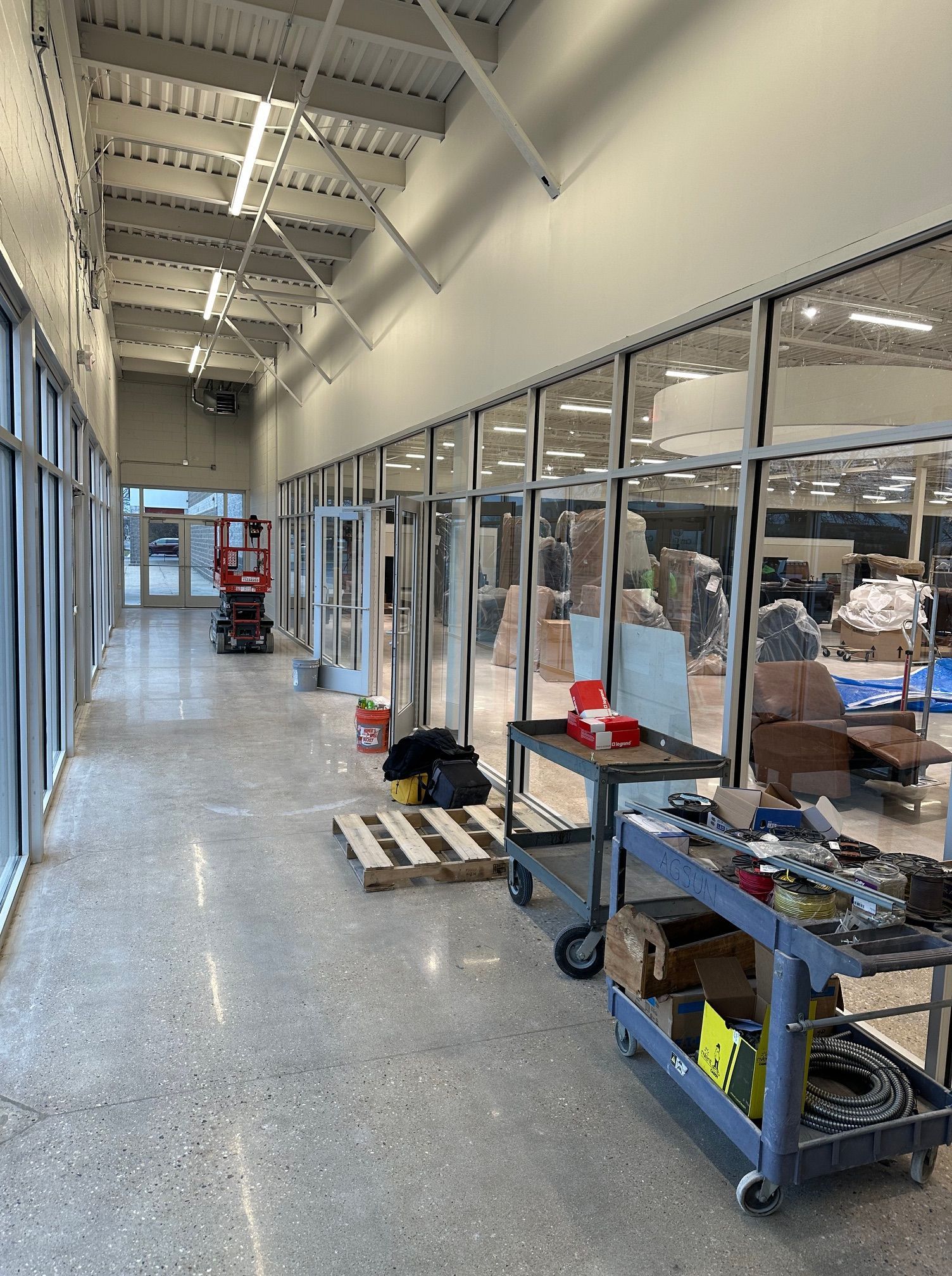 A long hallway in a building with a lot of windows.