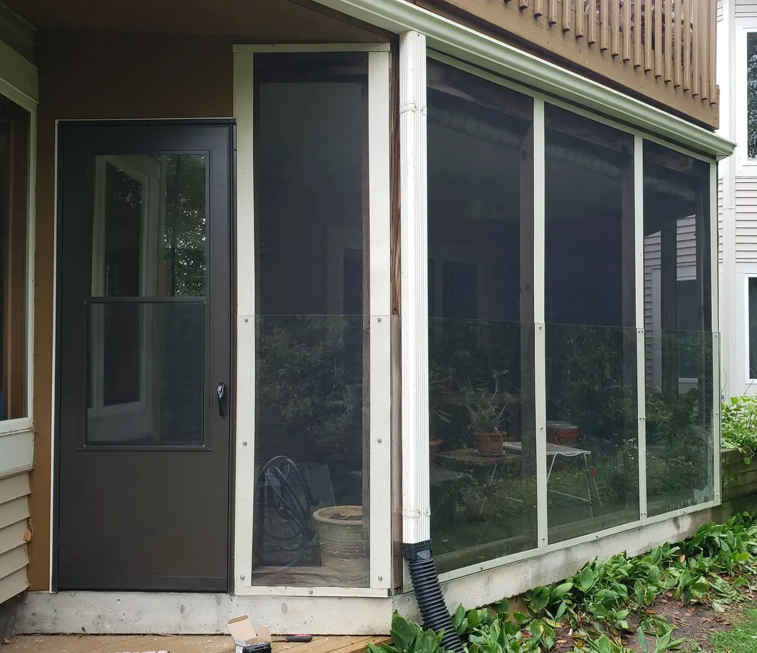 A screened in porch with a black door