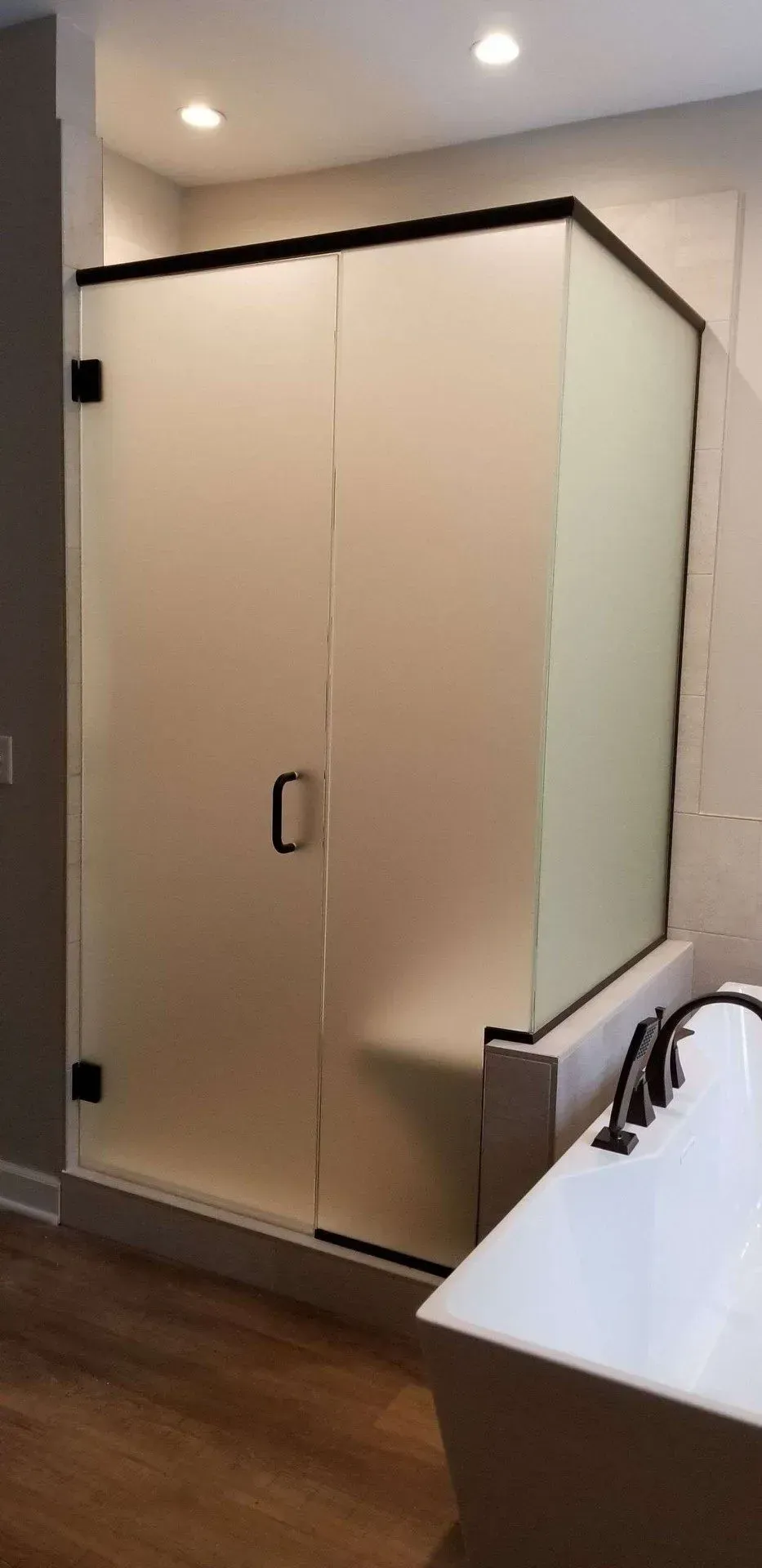 A bathroom with a walk in shower and a bathtub.