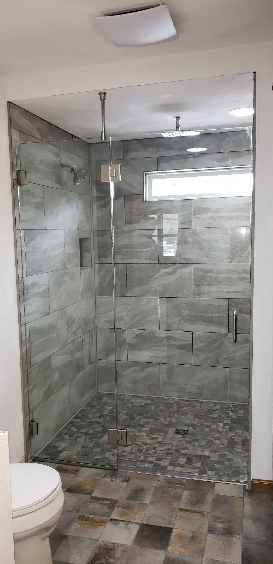 A bathroom with a walk in shower and a toilet.