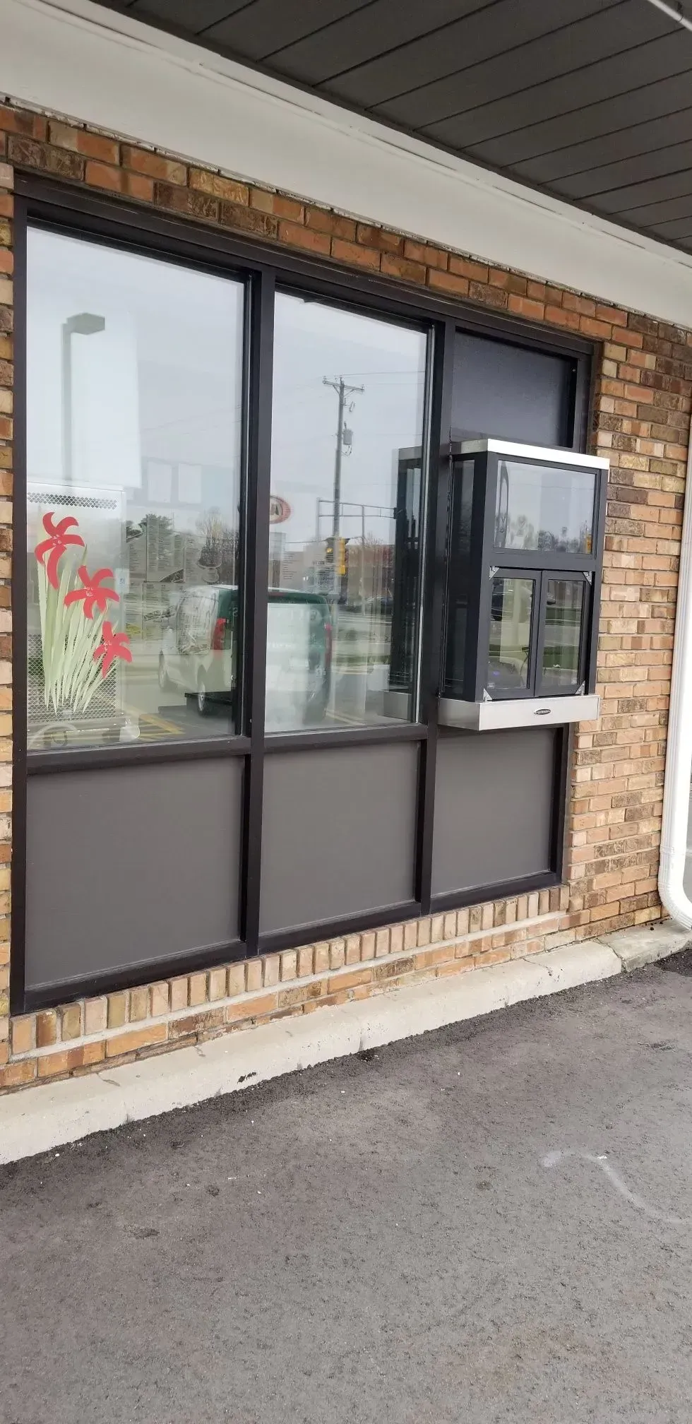 A brick building with a drive thru and a window.