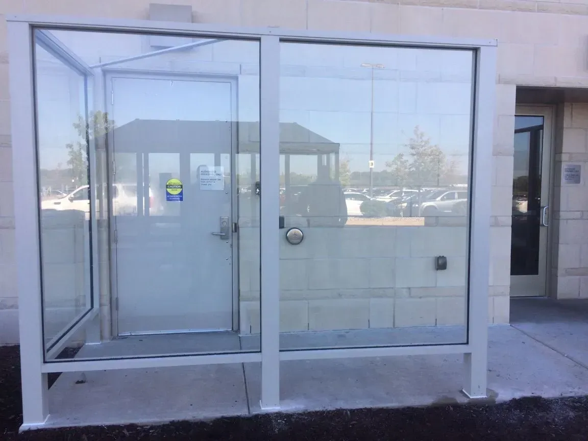 A glass door with a white frame is sitting outside of a building.