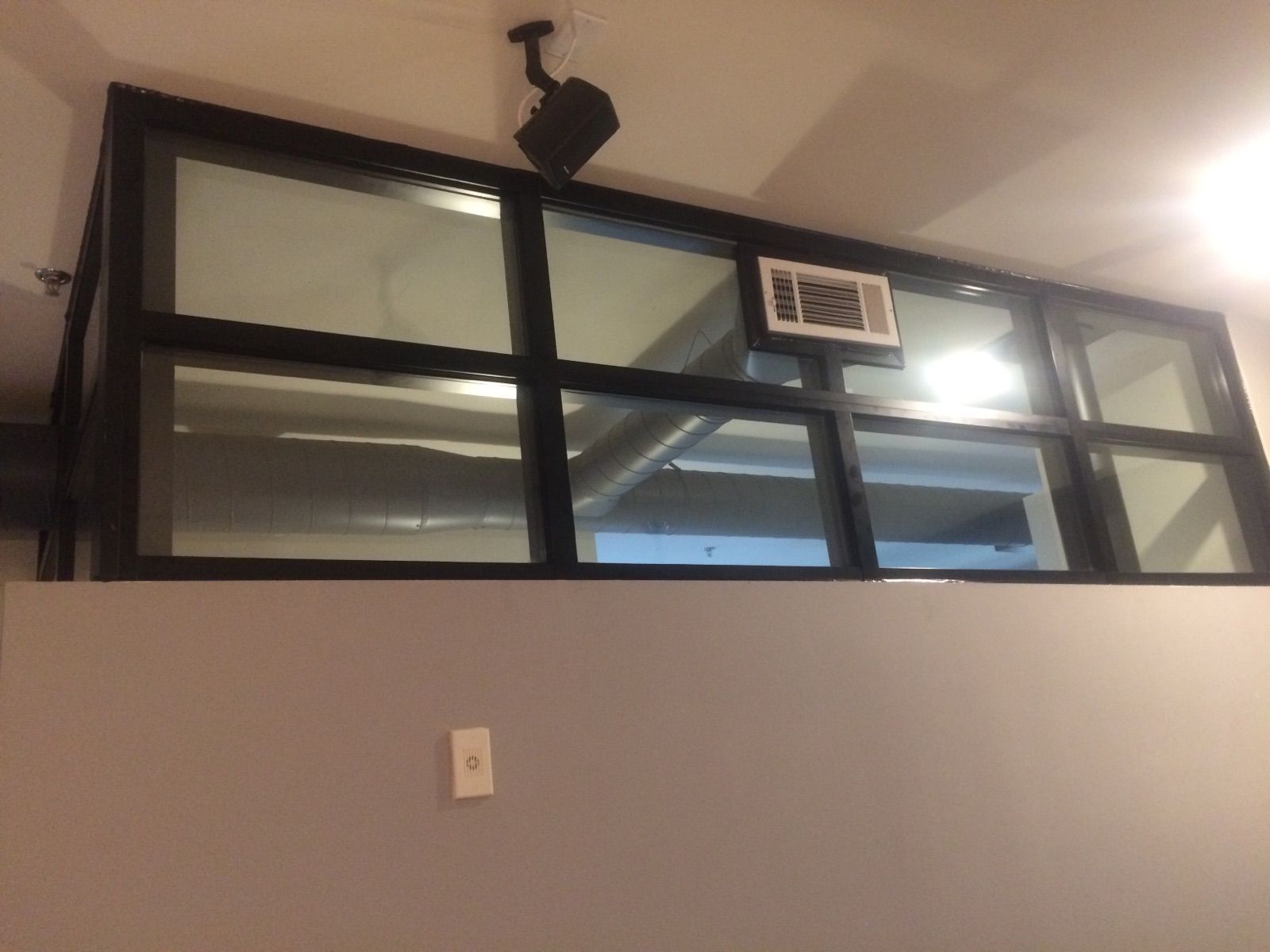 A room with a lot of windows and a ceiling fan