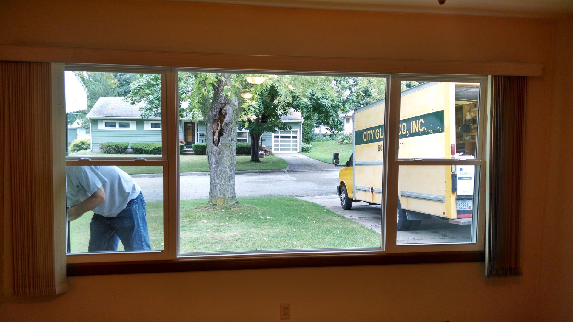 A man is looking out of a window at a delivery truck