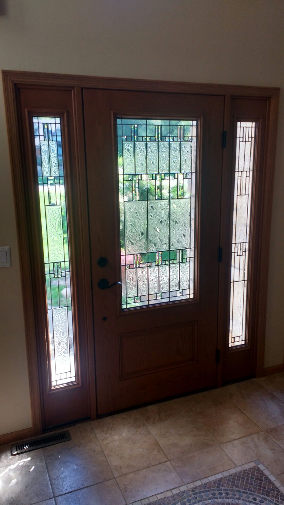 A wooden door with stained glass windows in a hallway.