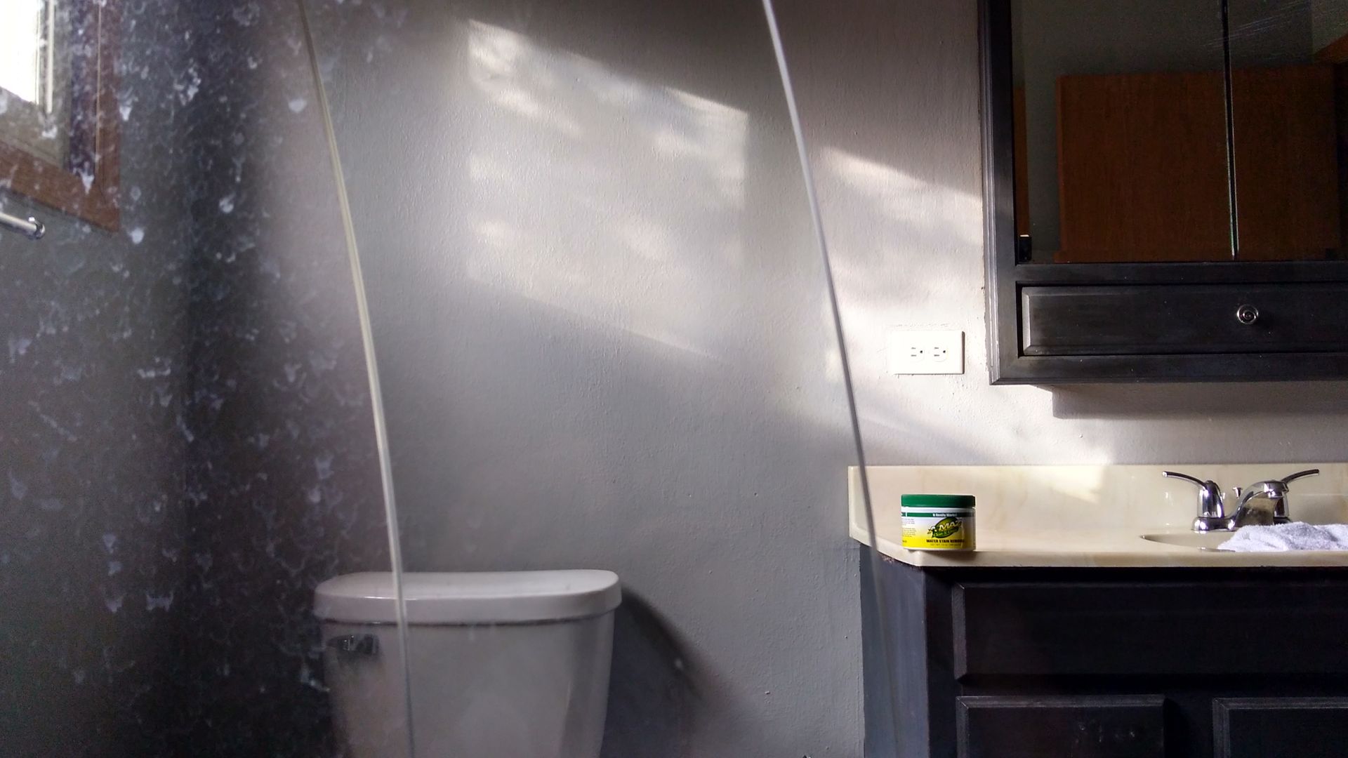 A bathroom with a toilet a sink and a mirror