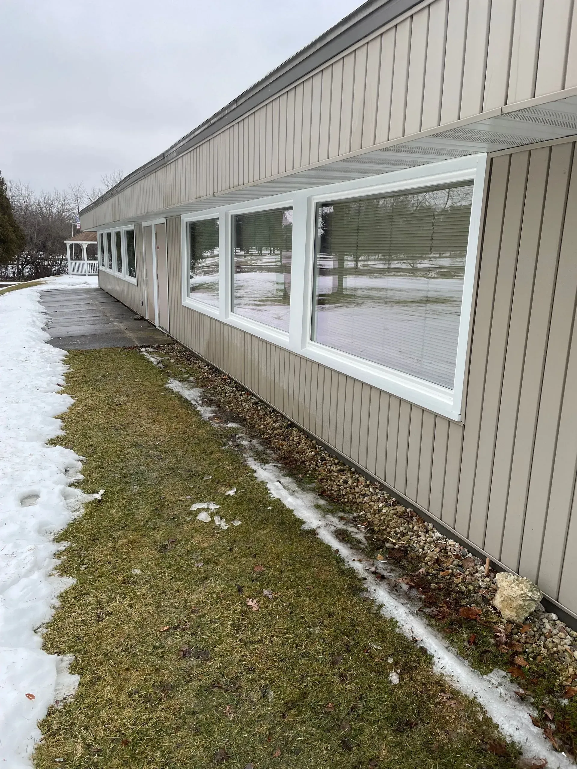 A building with a lot of windows and snow on the ground.