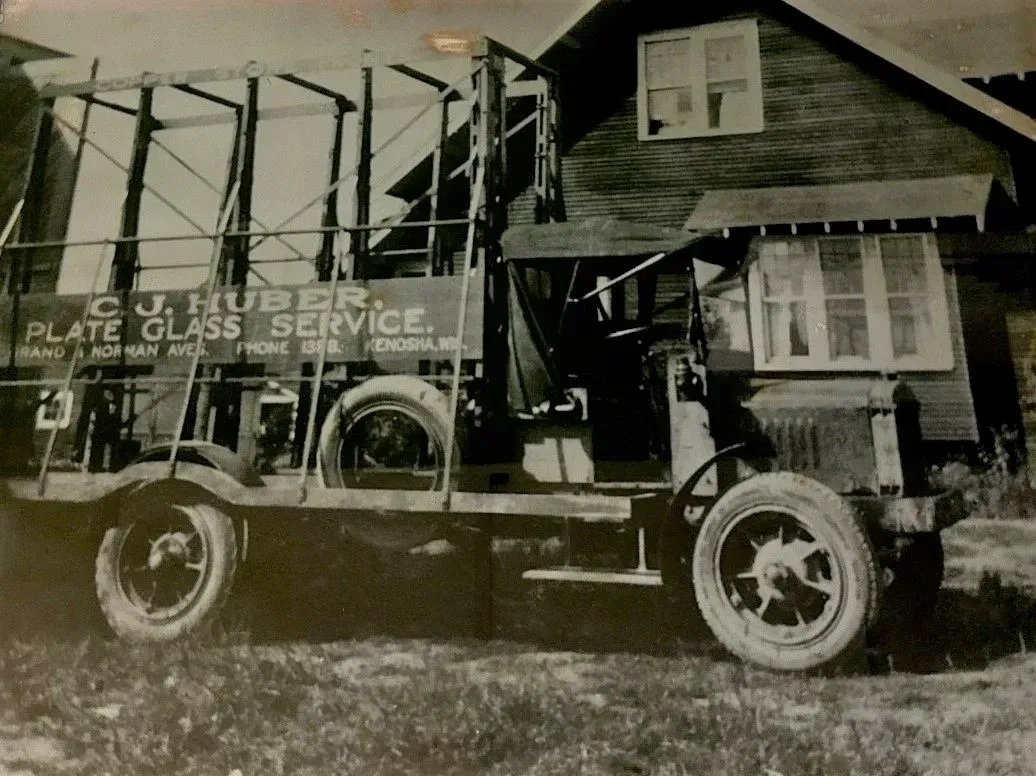 A black and white photo of a truck that says plate glass service