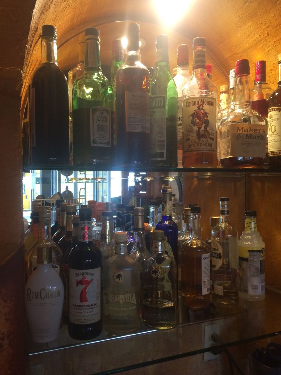 A shelf full of liquor bottles including a bottle with the number 7 on it