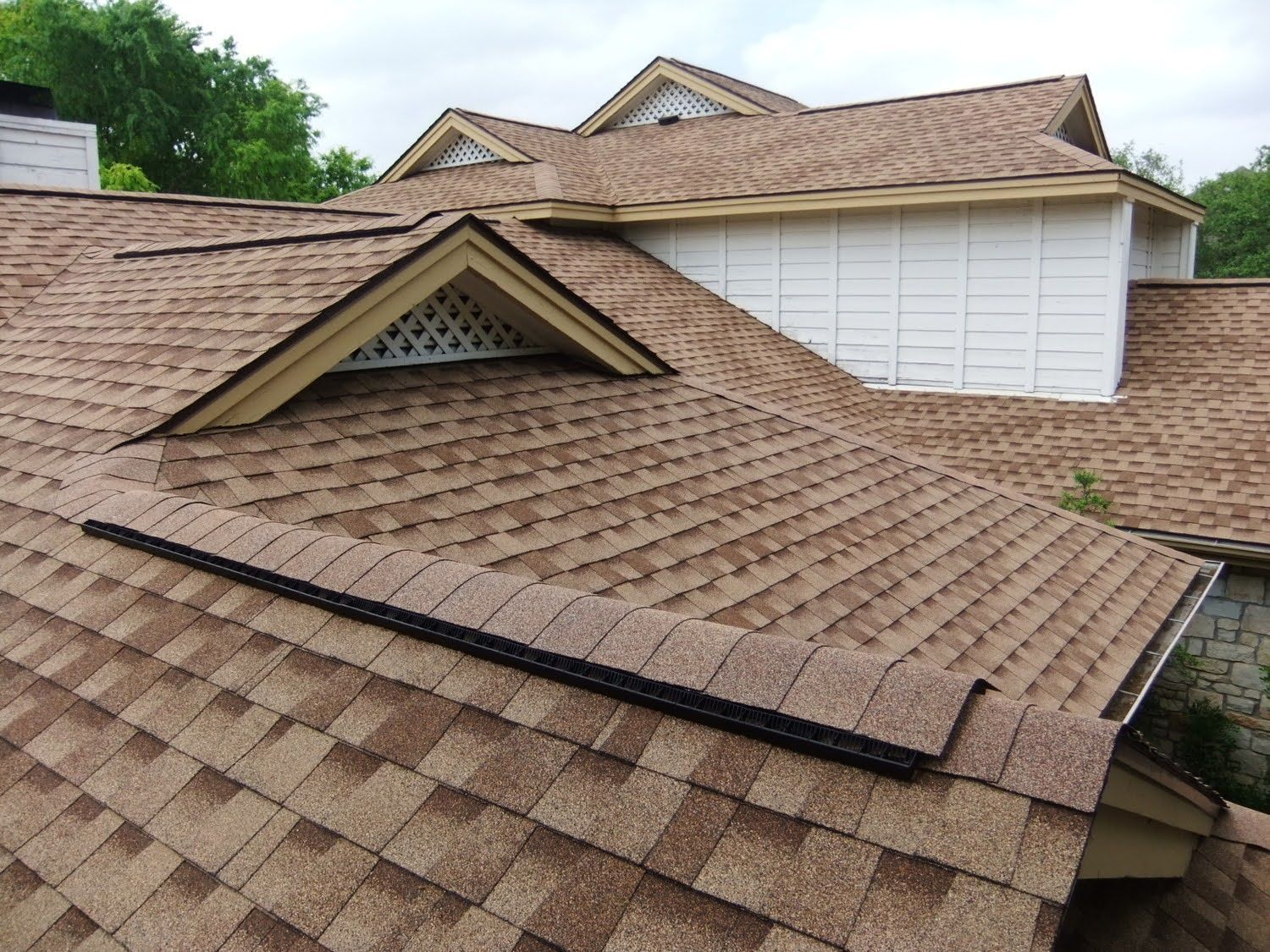 the roof of a house with a brown shingle roof