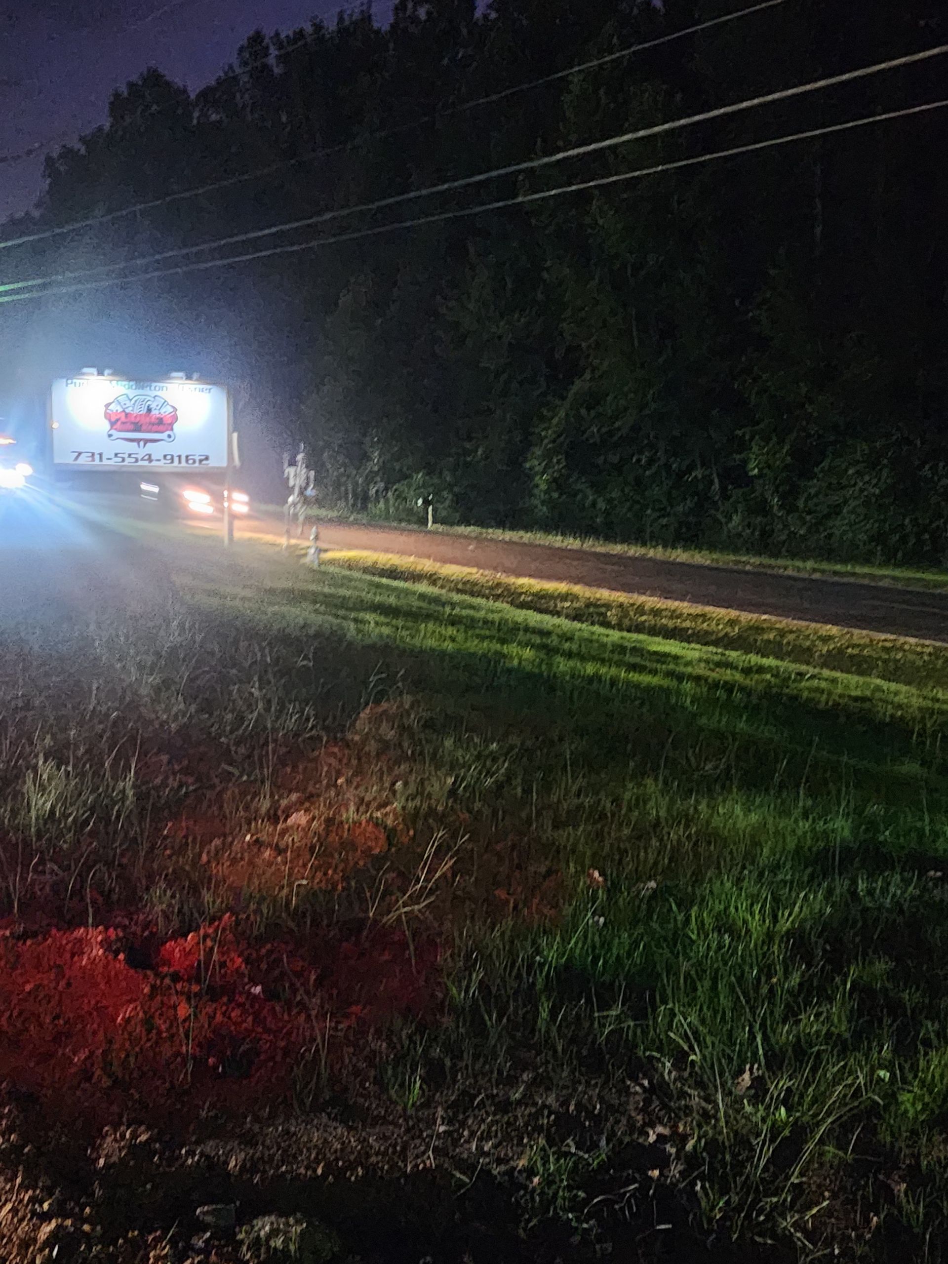 A truck is driving down a road at night.