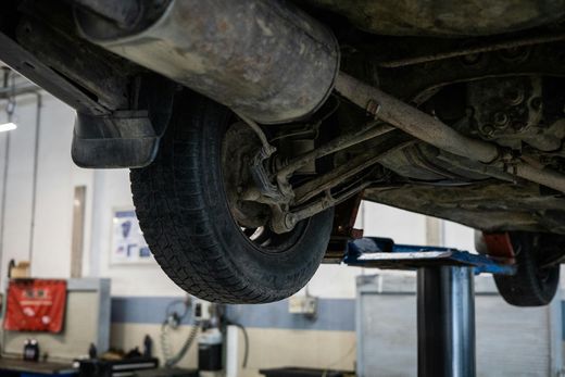 A car is sitting on a lift in a garage.