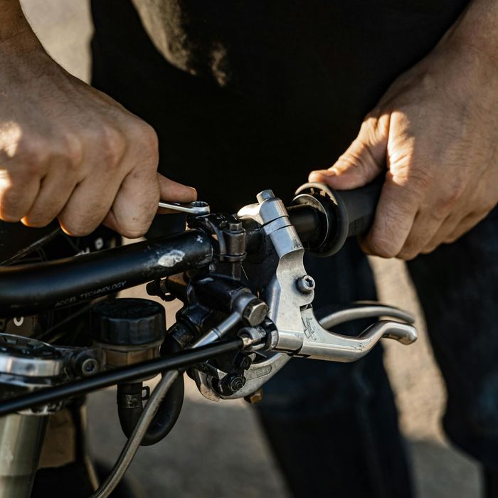 A man is adjusting the brake lever on his bike