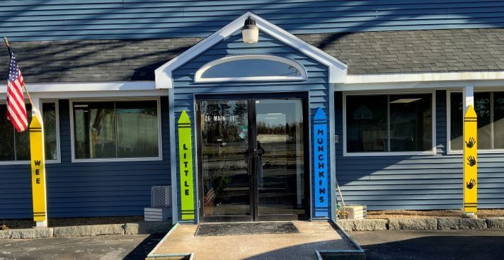 A blue building with a yellow pole in front of it and an american flag.