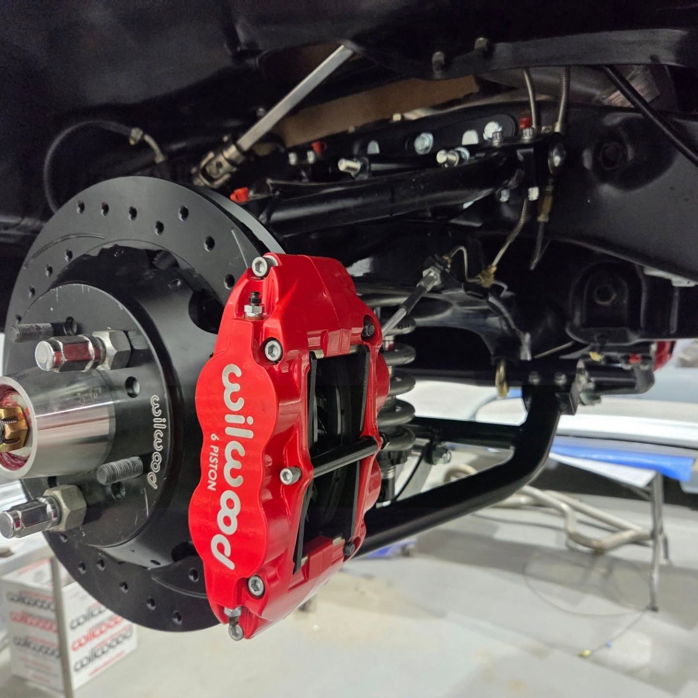 A close up of a red wilwood brake on a car