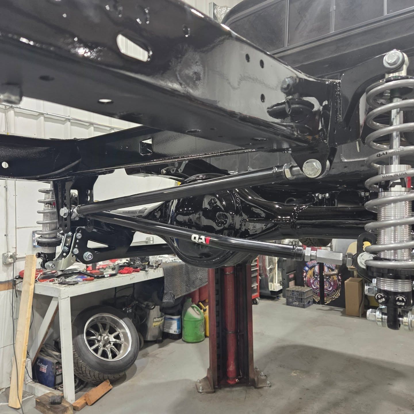 A truck is sitting on a lift in a garage.