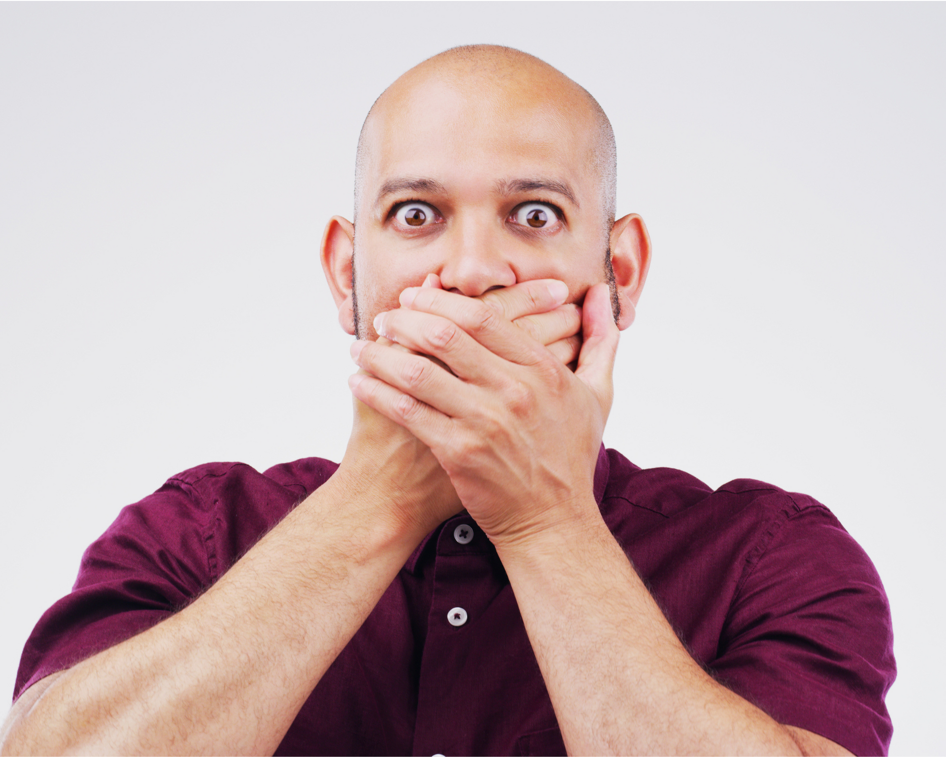 man covering his mouth in surprise