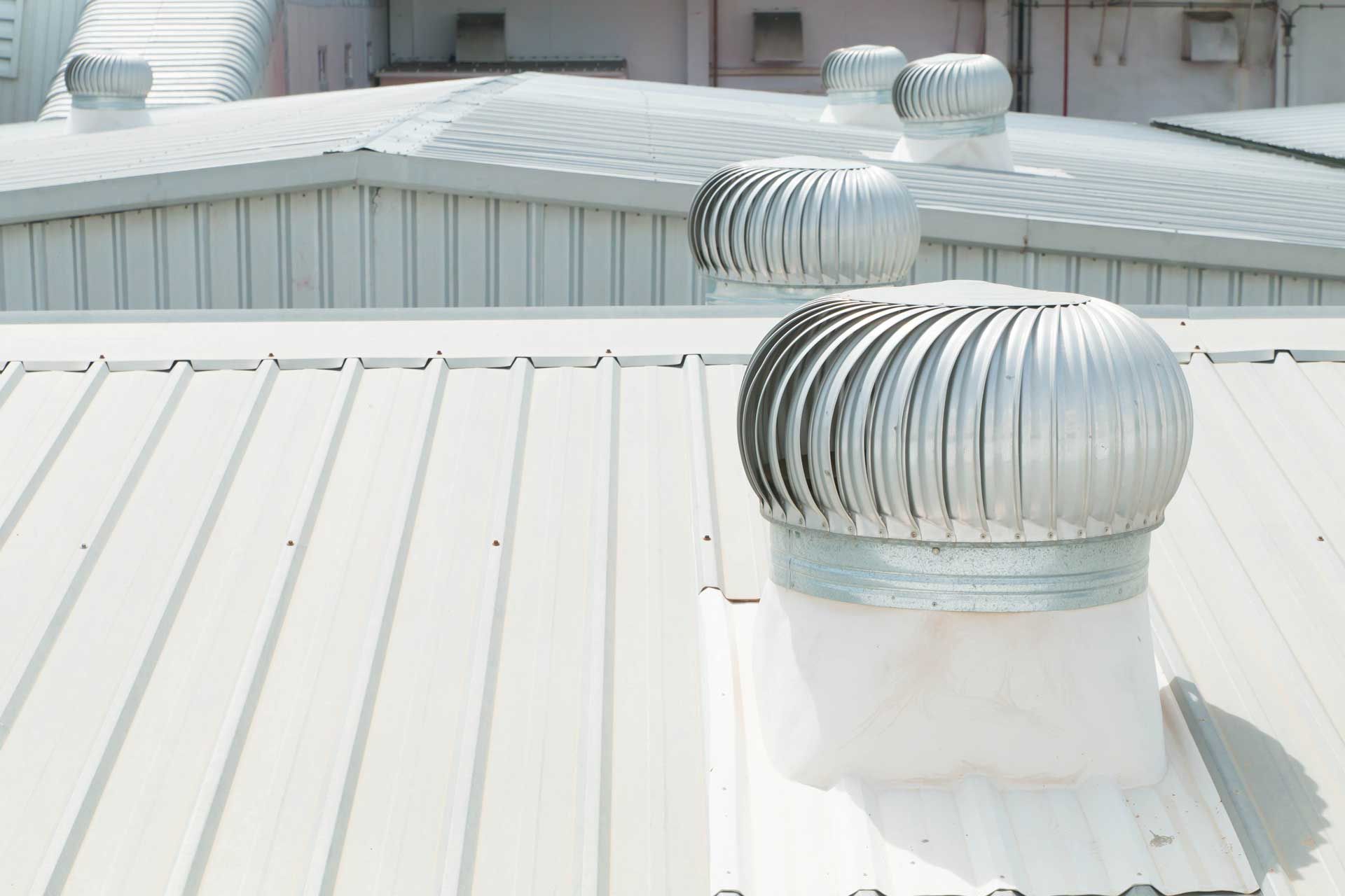 Metallic roof with several spinning ventilation turbines.