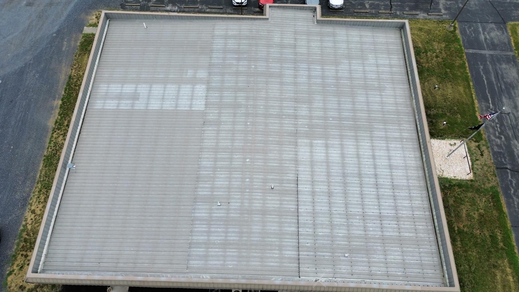Construction worker applying sealant to a building rooftop.