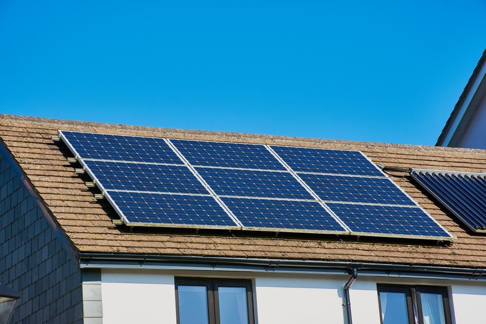 There Are Many Solar Panels on The Roof of A House — Peter Gow Electrical in Lismore, NSW