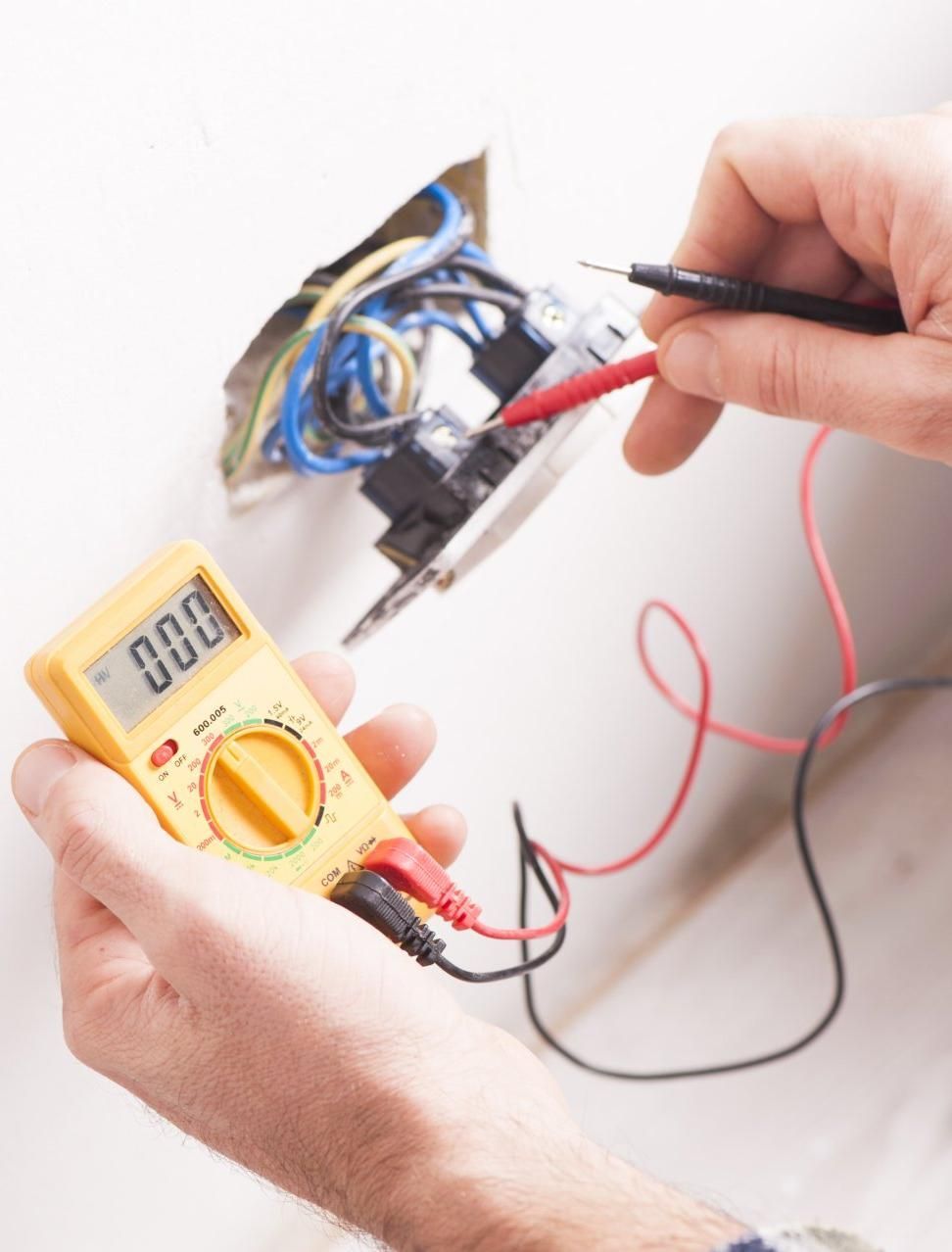 A Person Is Using a Digital Multimeter to Check a Socket — Peter Gow Electrical in Goonellabah, NSW