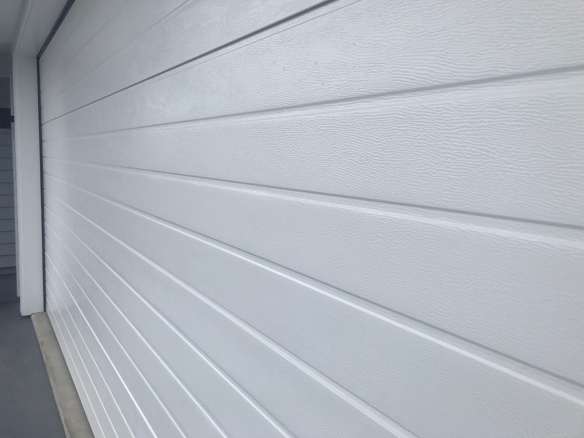 A close up of a white garage door on a house.
