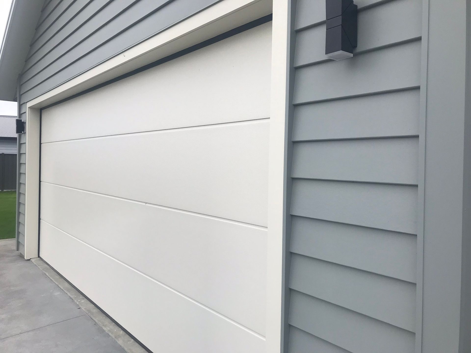 A white garage door is on the side of a house.