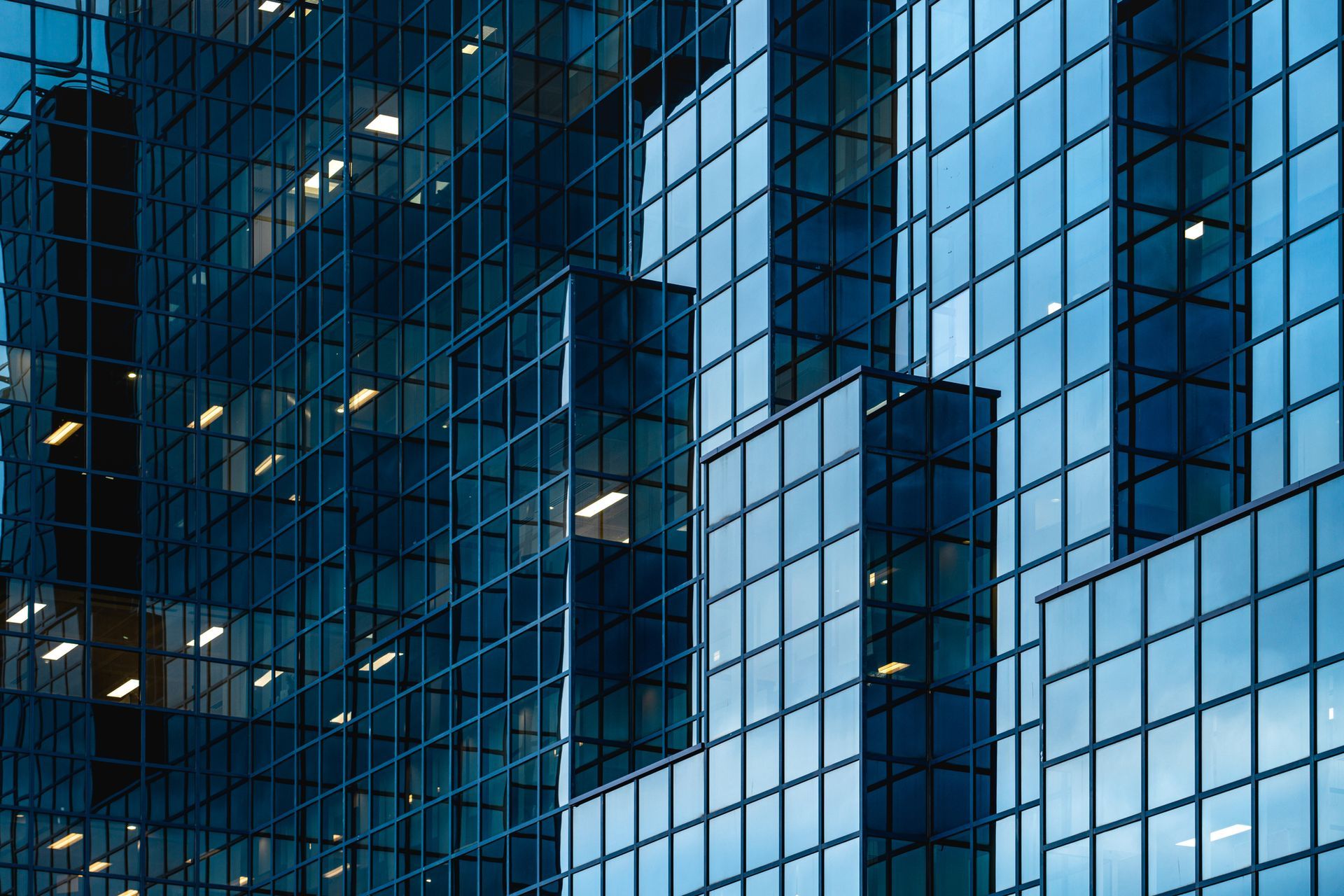 Blue glass skyscraper facade reflecting the sky.