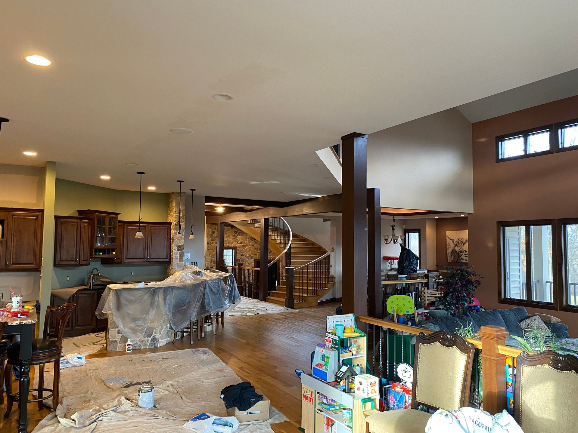 A large room with a lot of furniture and a staircase in the background.