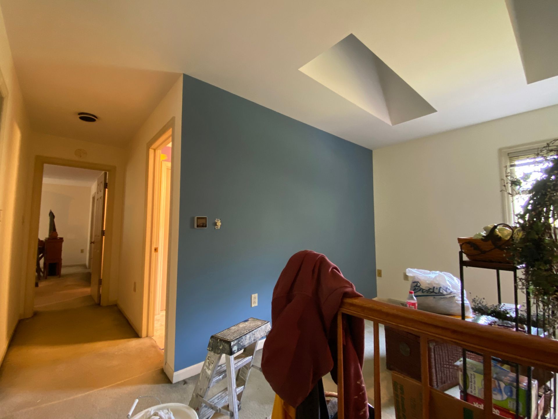 A room with a blue wall and a ladder in it.