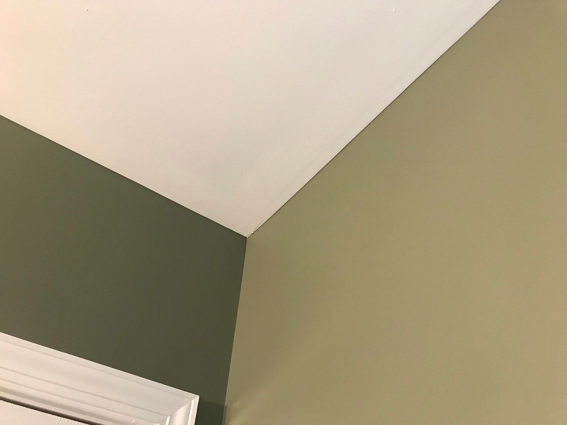 A corner of a room with green walls and a white ceiling.