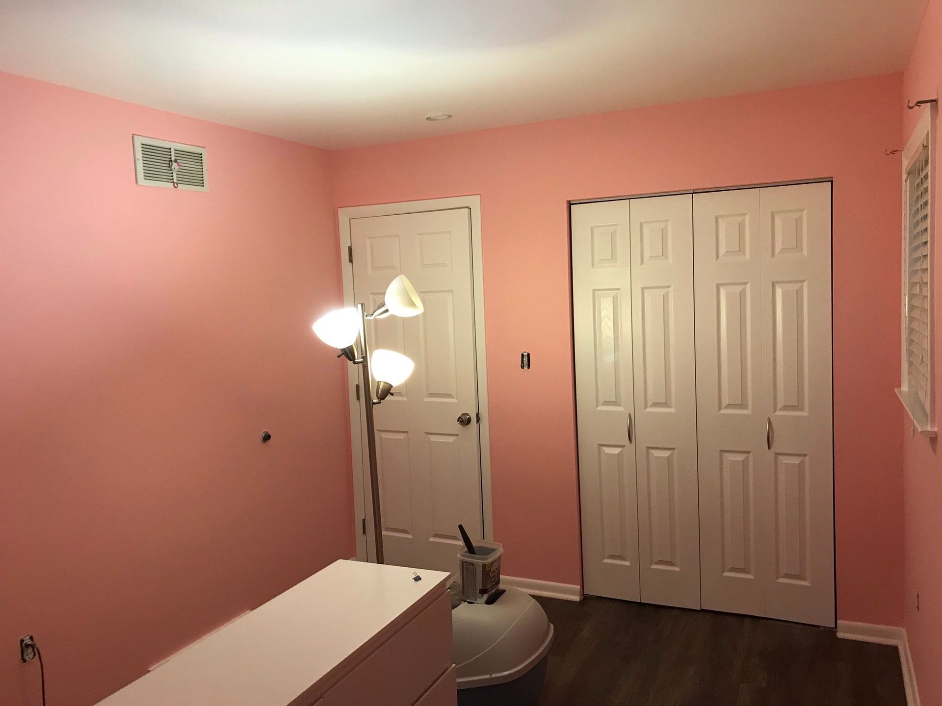 A room with pink walls and white doors.