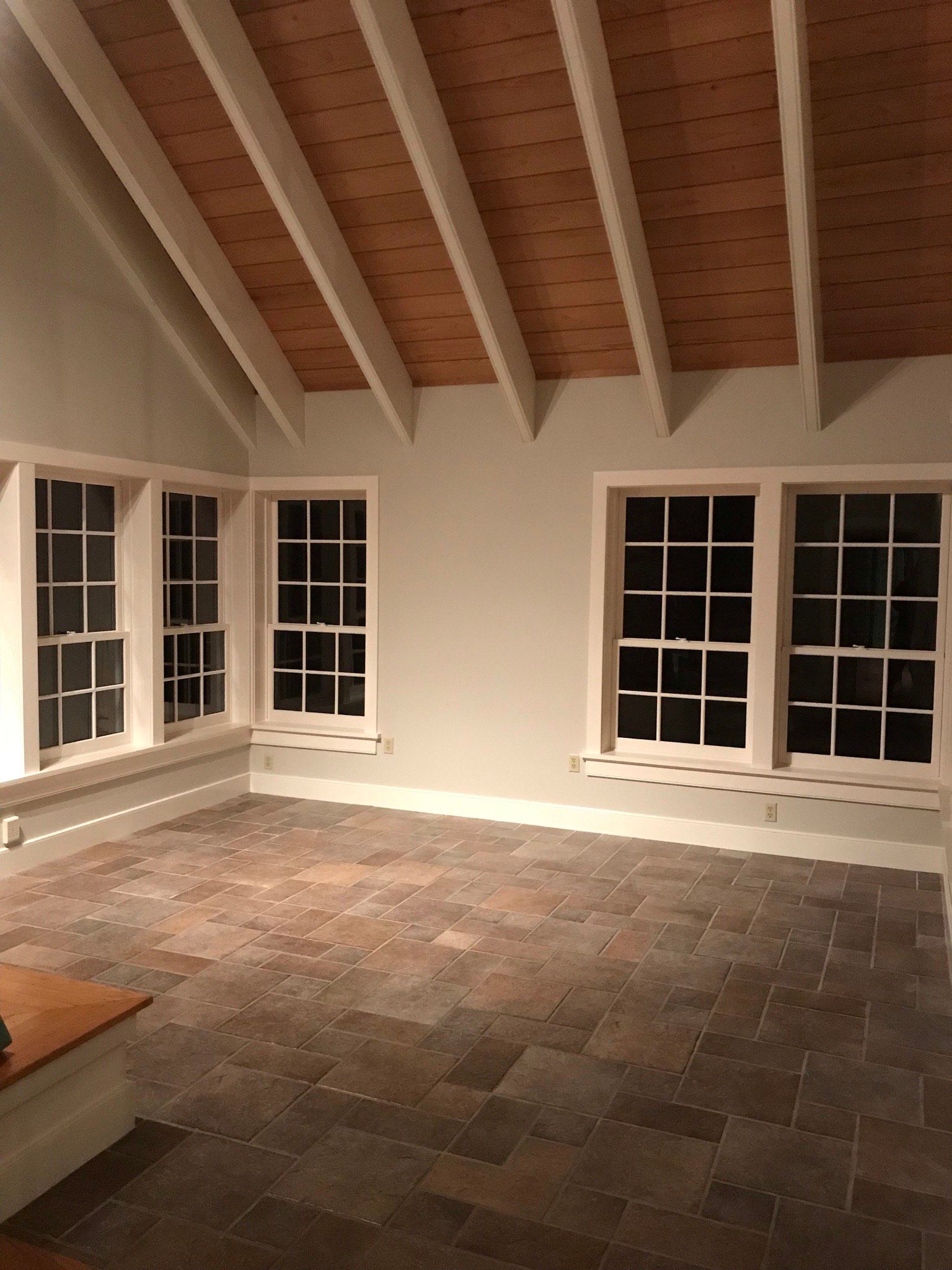An empty room with a tiled floor and a wooden ceiling