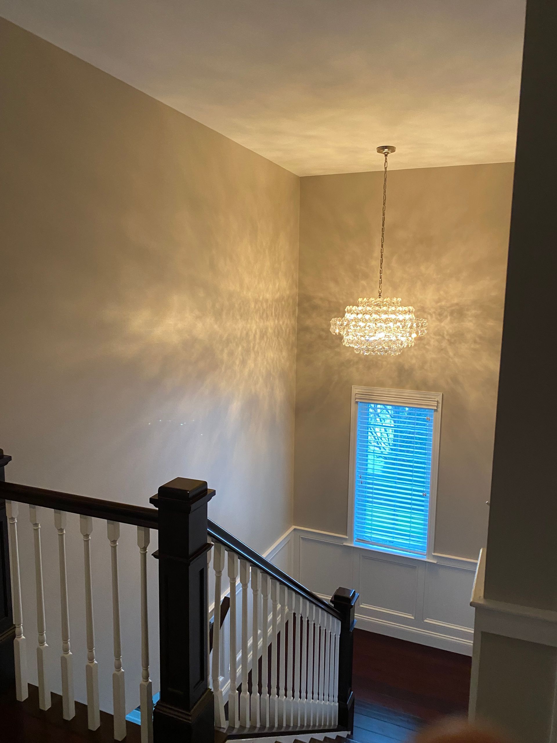 A staircase with a chandelier hanging from the ceiling