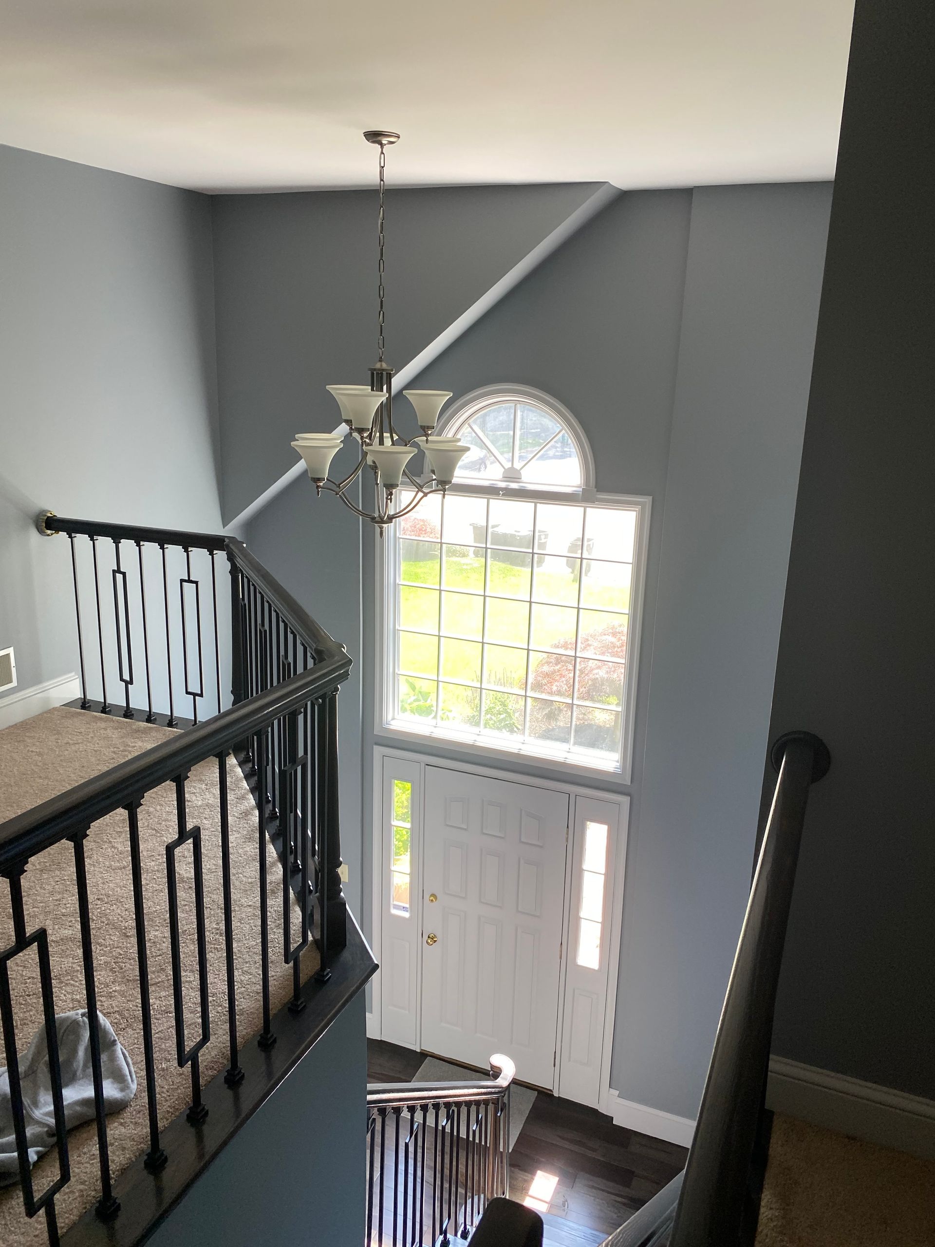 A staircase with a chandelier hanging from the ceiling in a house.
