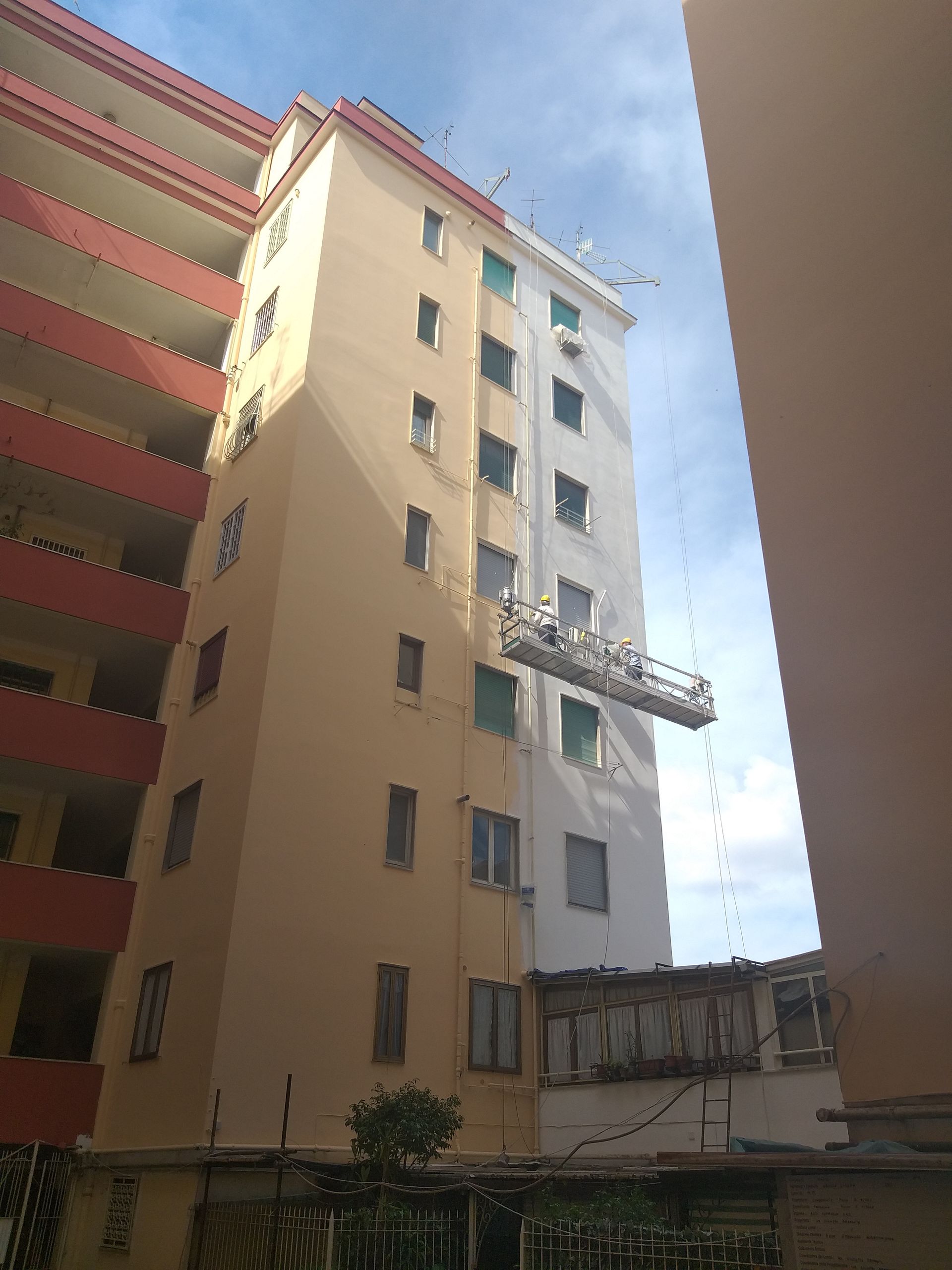 Un edificio alto con una gru su un lato.