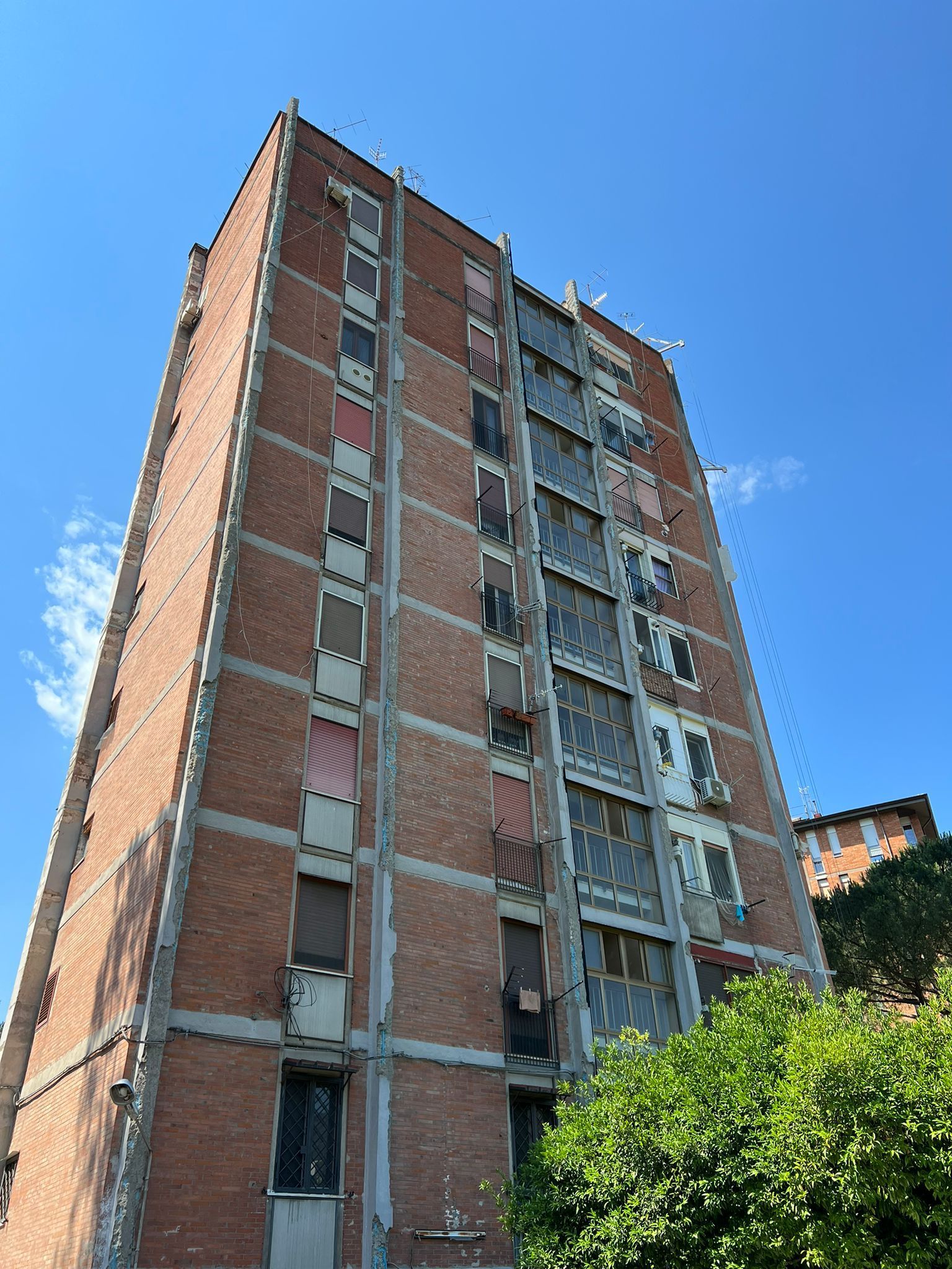 Un alto edificio in mattoni con un cielo azzurro sullo sfondo.