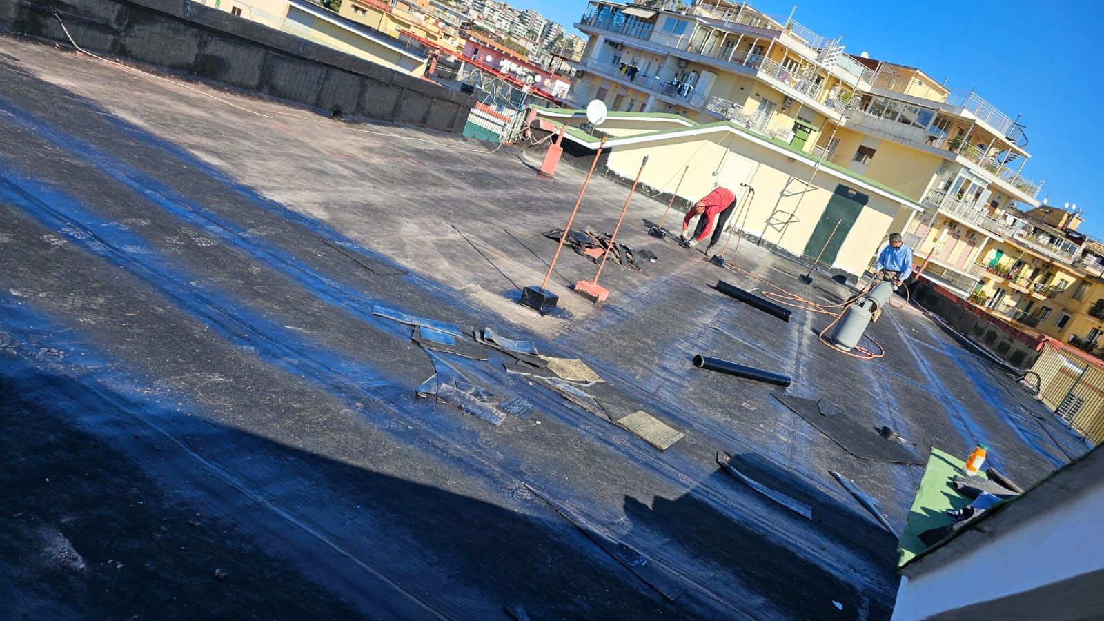 Un gruppo di persone sta lavorando sul tetto di un edificio.