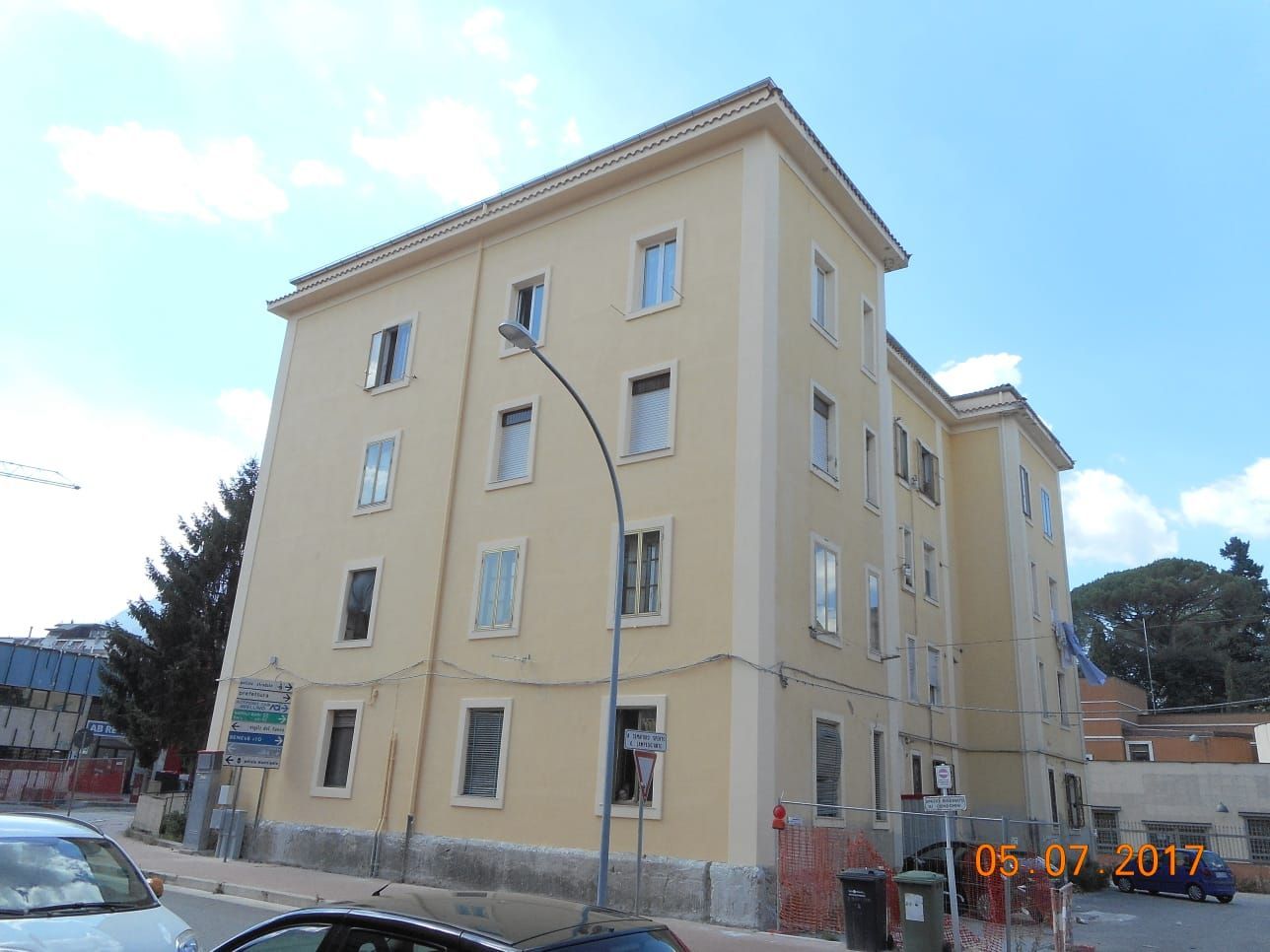 Un edificio con molte finestre e un'auto parcheggiata di fronte