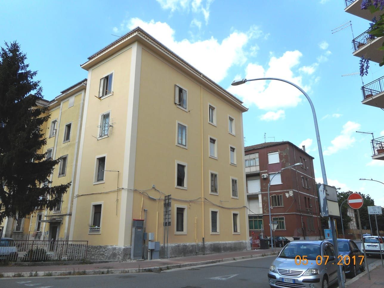 Un edificio giallo con auto parcheggiate davanti