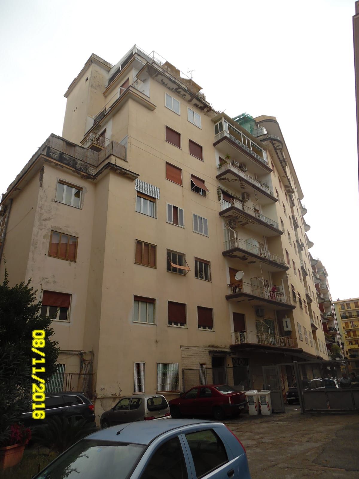 Un grande condominio con le auto parcheggiate davanti.