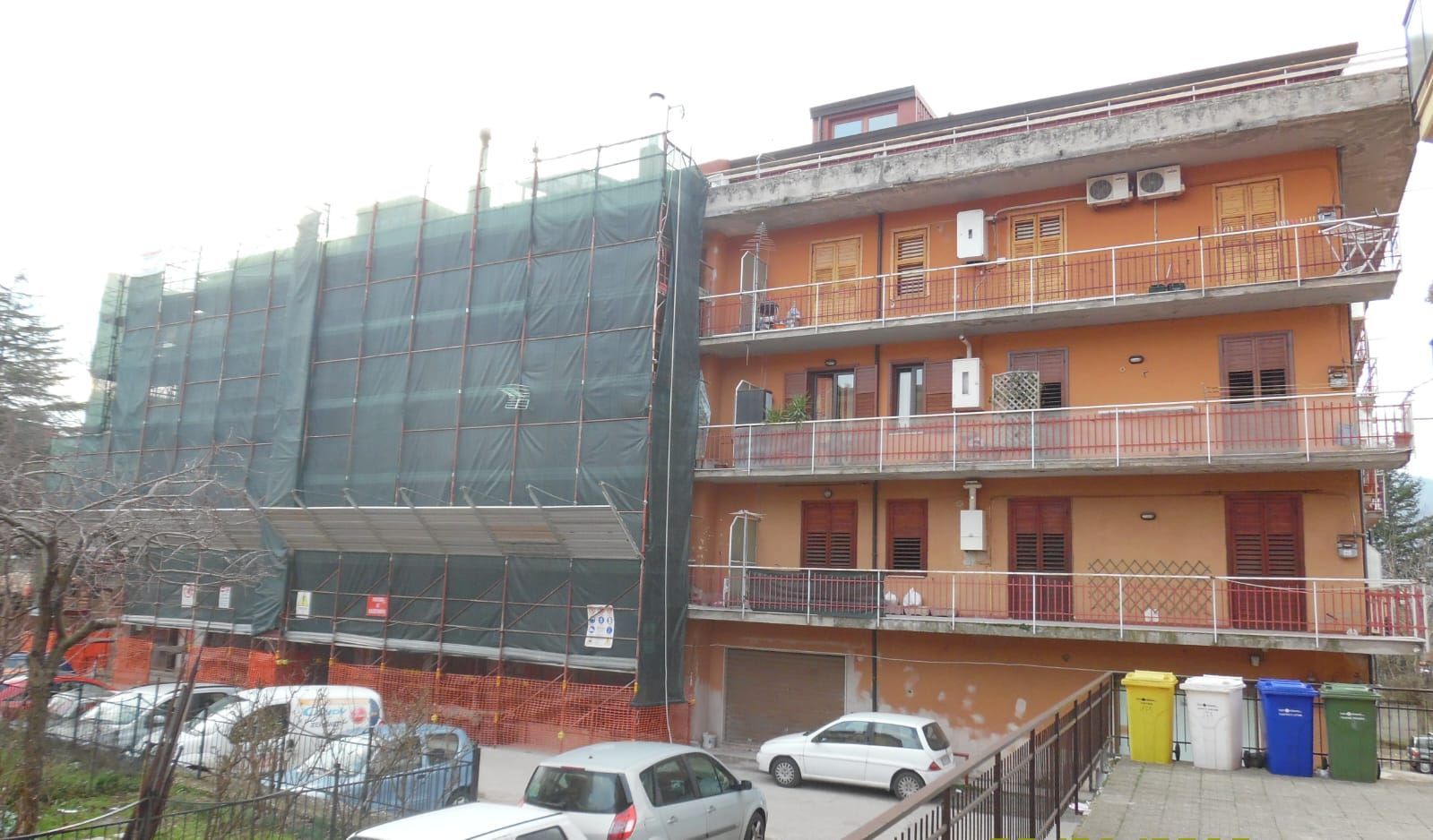 Un edificio in costruzione con auto parcheggiate davanti