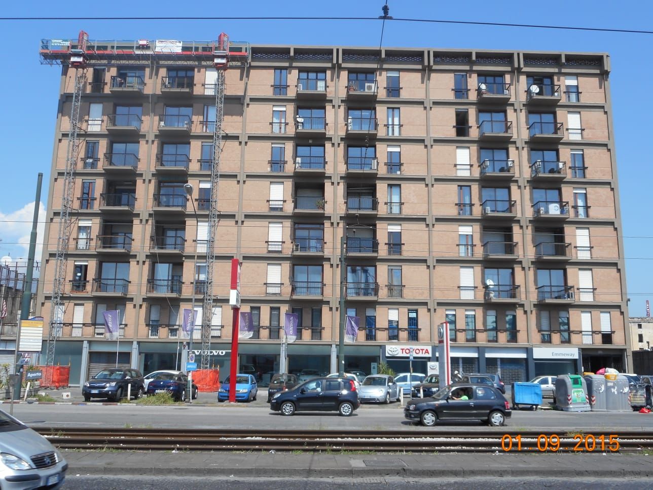 Un grande condominio con auto parcheggiate davanti